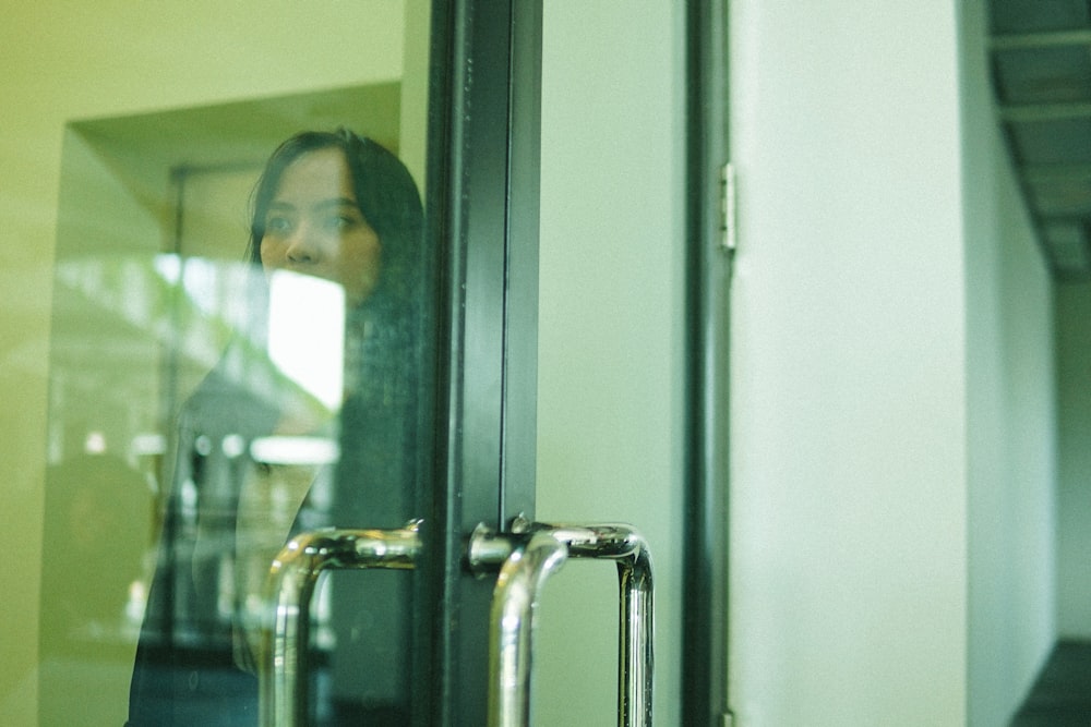 woman in white shirt taking selfie in front of mirror