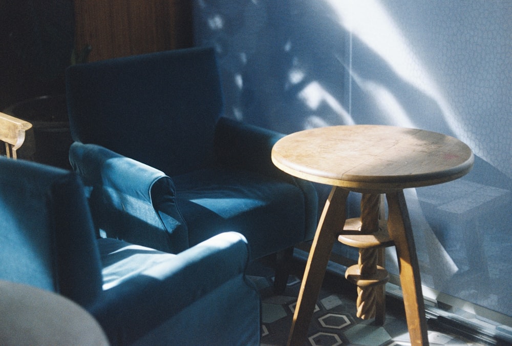 round brown wooden table beside blue sofa