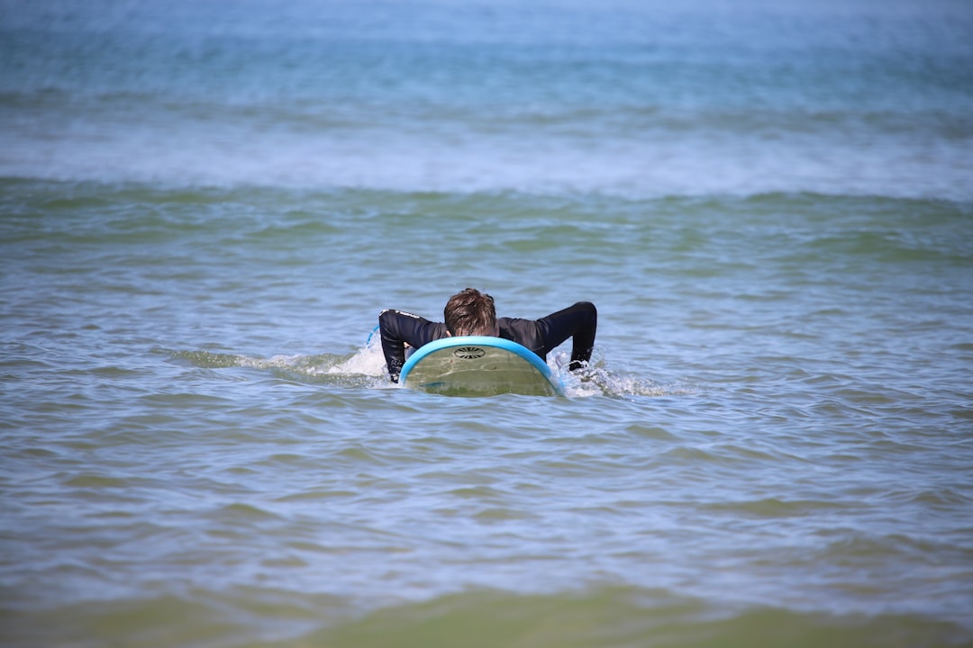 man in black wetsuit surfing on sea waves during daytime