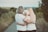 woman in blue t-shirt hugging white dog