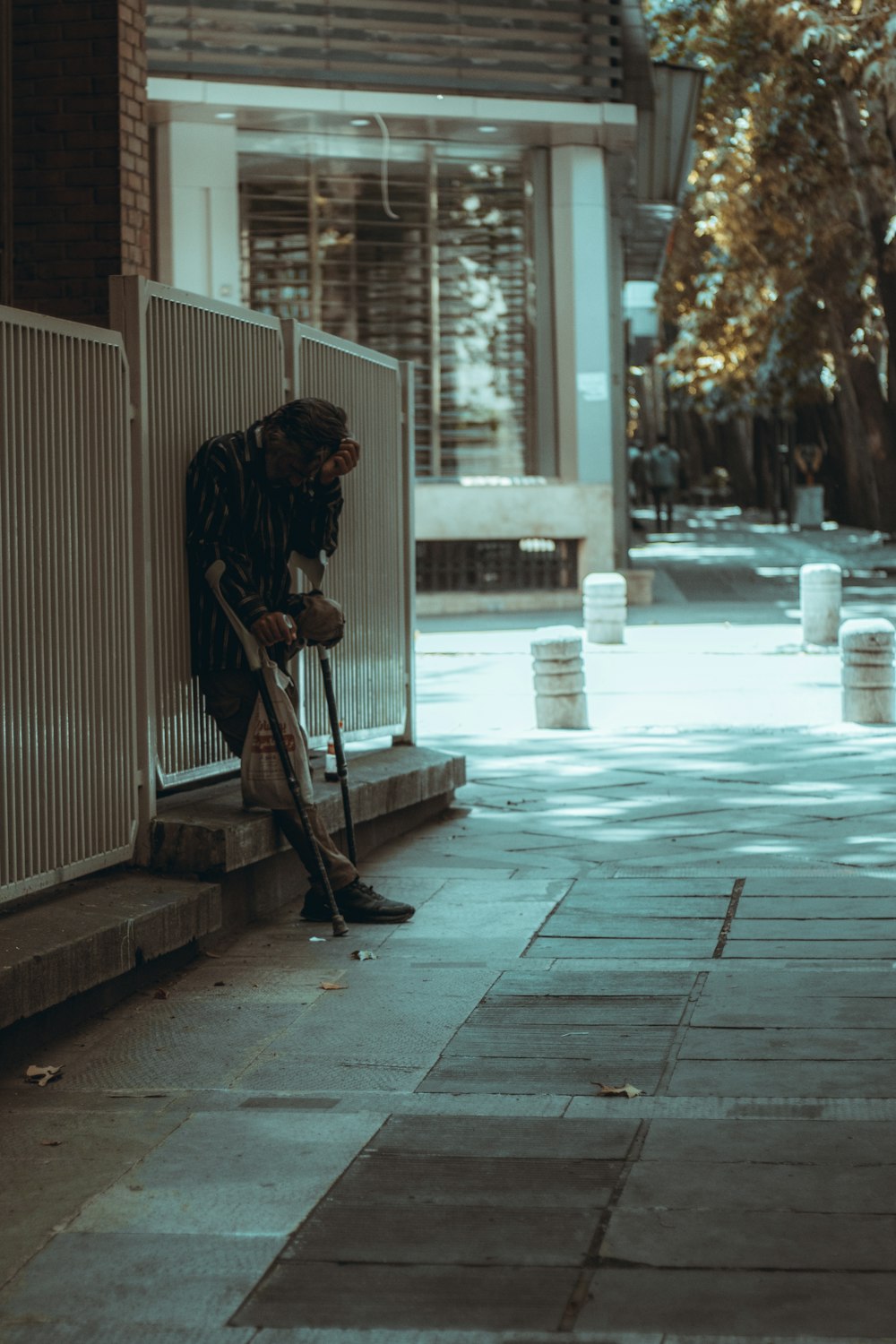 man in black and white stripe dress shirt and black pants holding brown wooden stick