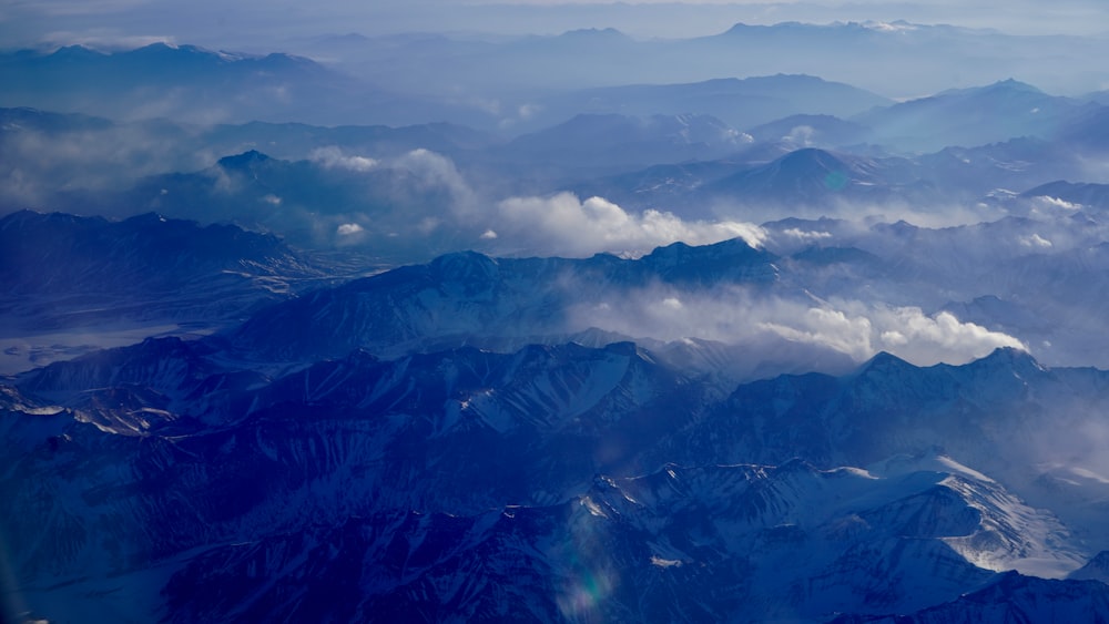 aerial view of mountains under cloudy sky during daytime