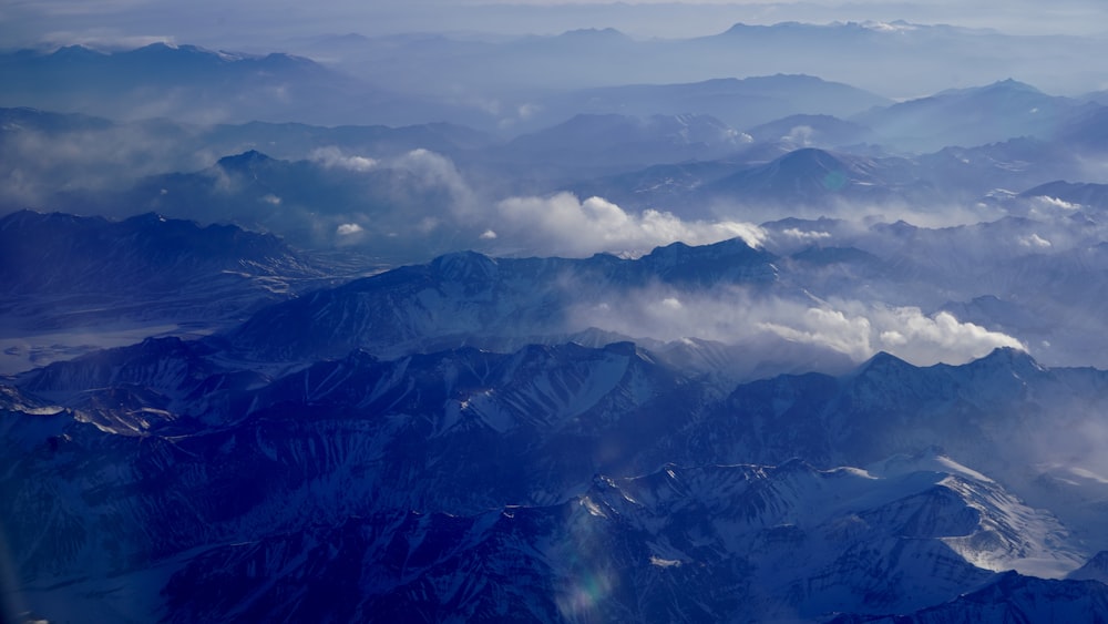 aerial view of mountains under cloudy sky during daytime