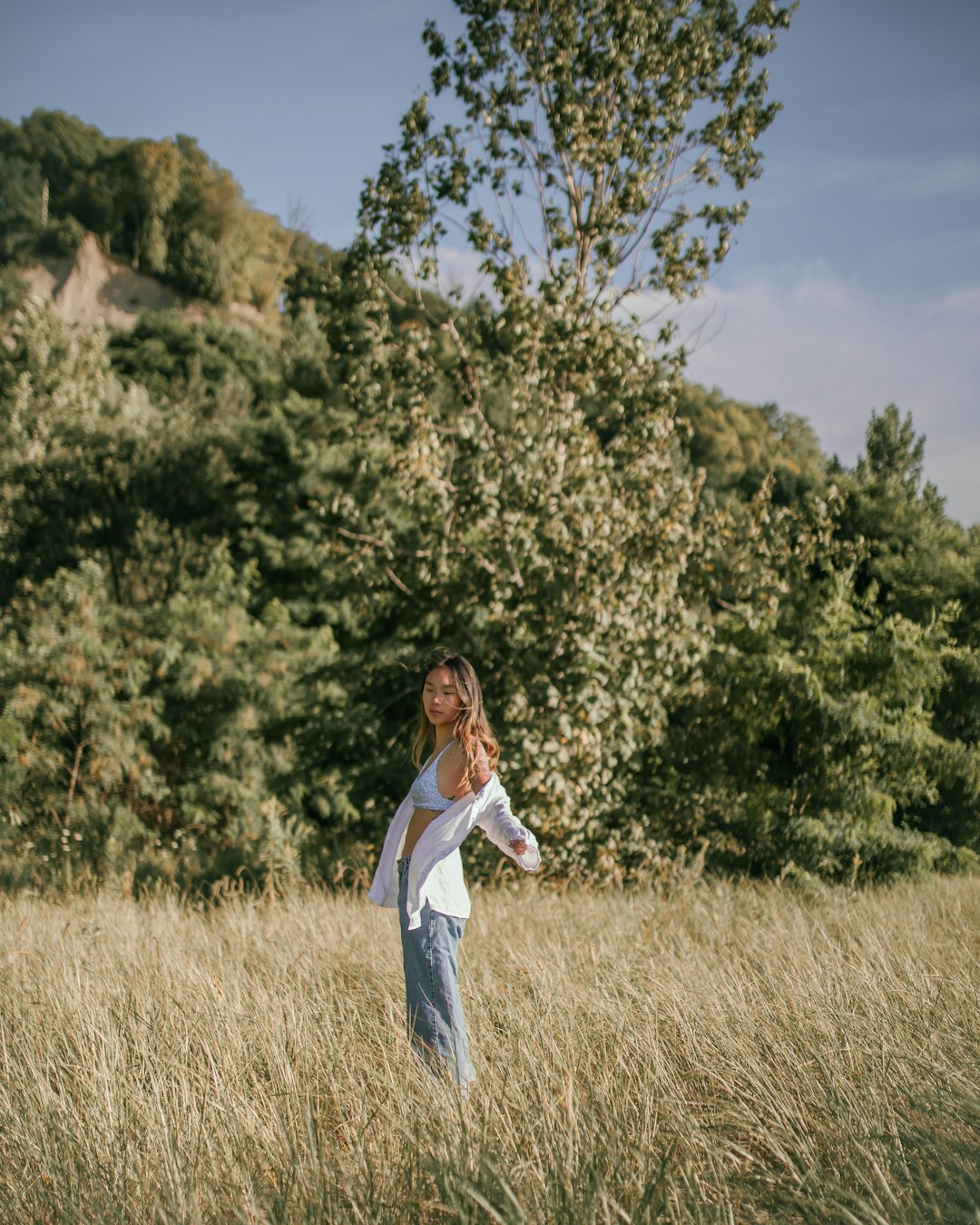 woman in white long sleeve dress standing on brown grass field during daytime