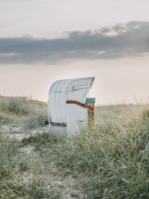 white and blue wooden chair on green grass field under white sky during daytime