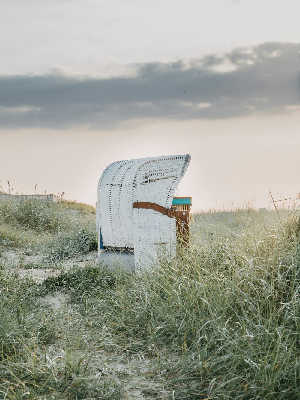 white and blue wooden chair on green grass field under white sky during daytime