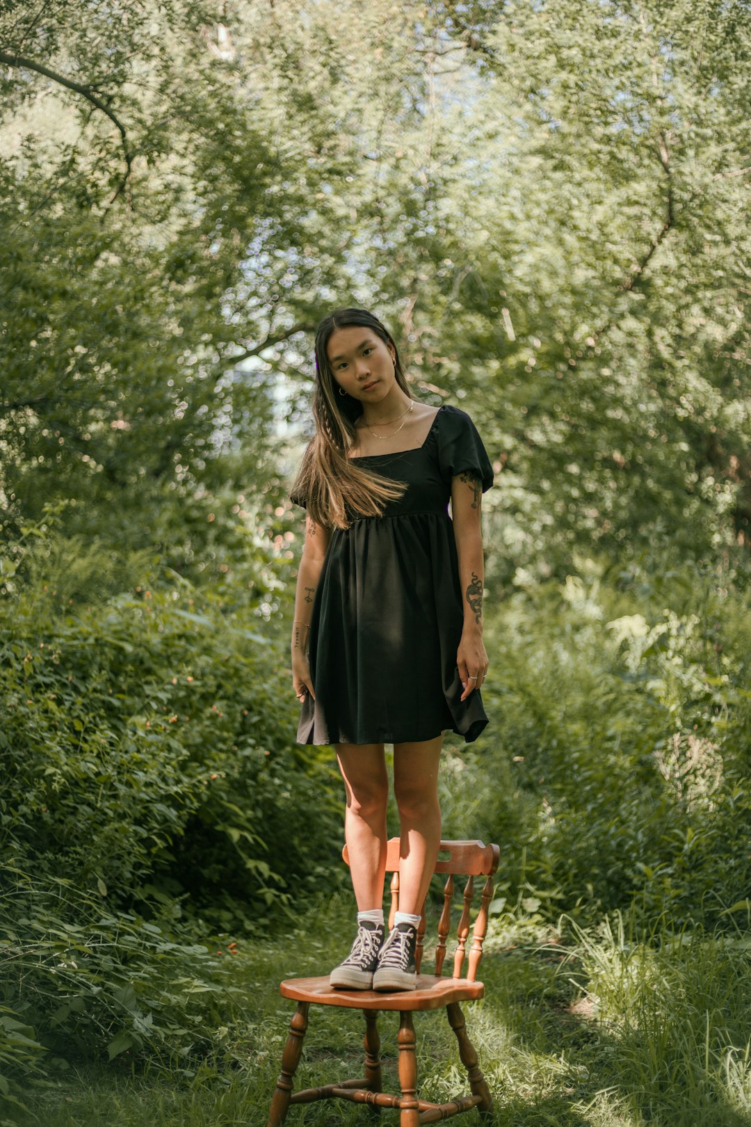 woman in black dress standing on green grass field during daytime