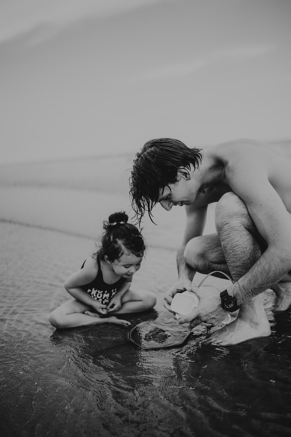 Foto en escala de grises de una pareja besándose en la playa