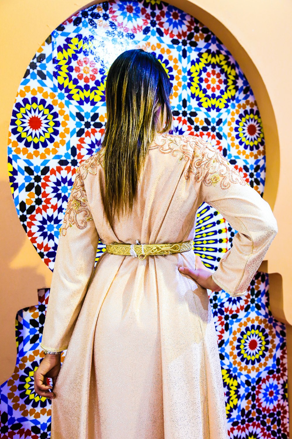 woman in beige coat standing near wall