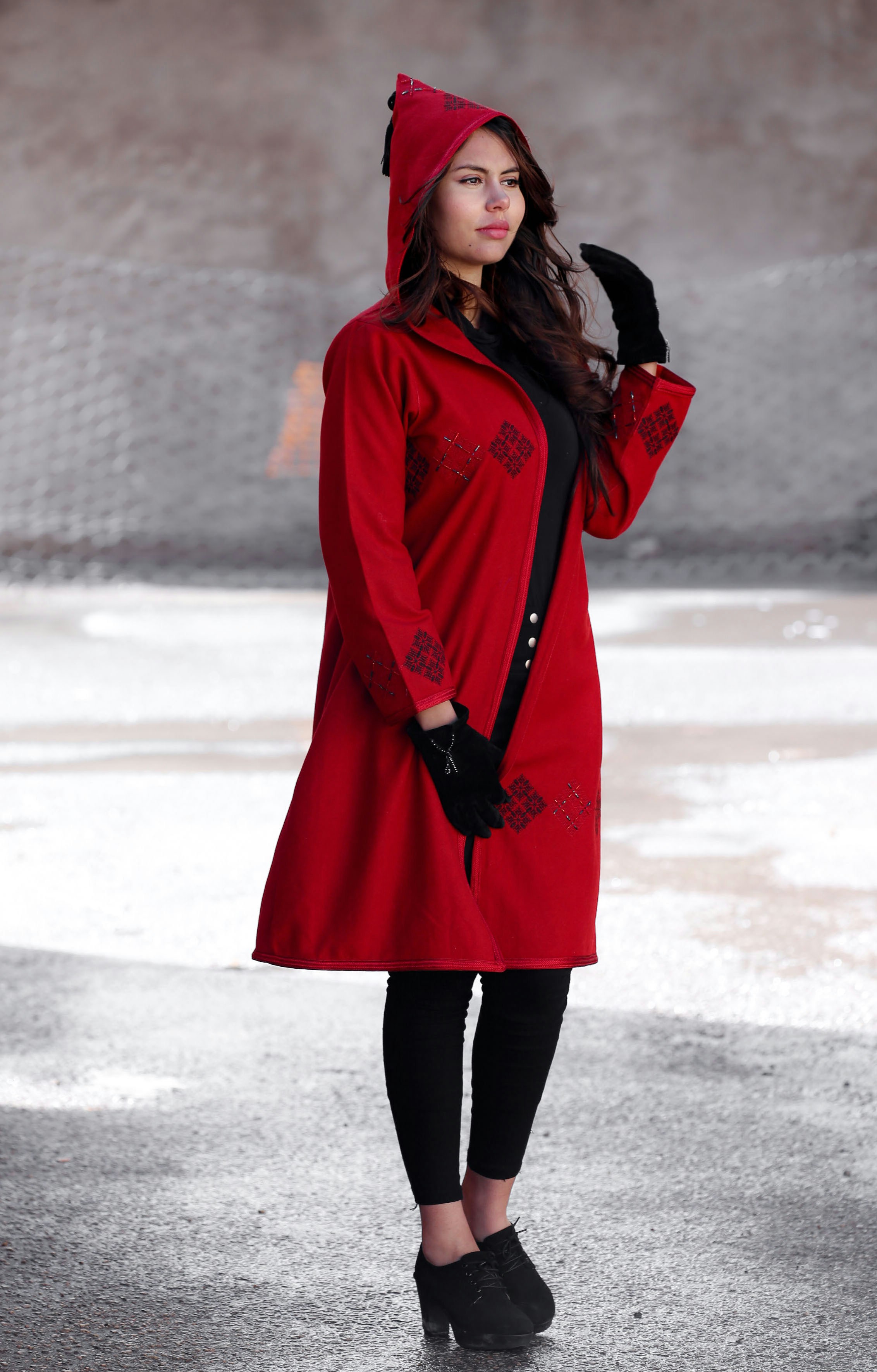 woman in red coat standing on snow covered ground during daytime