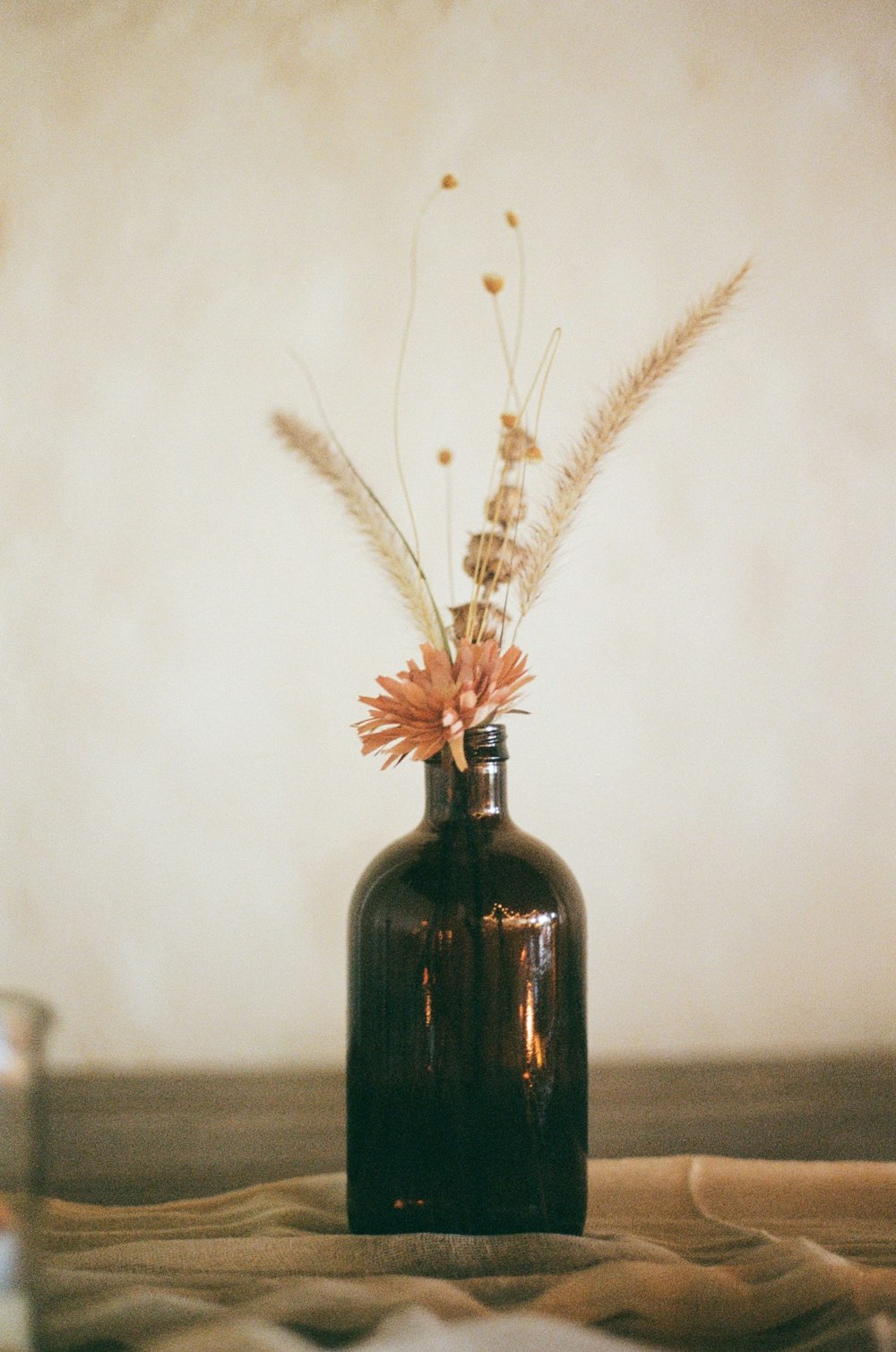 white flowers in black glass bottle