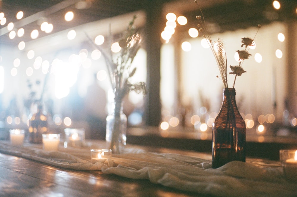 a table topped with a vase filled with flowers and candles