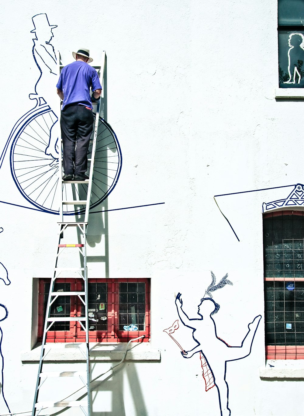 man in blue jacket and blue denim jeans riding bicycle