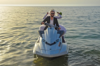 man and woman in white and blue boat on body of water during daytime