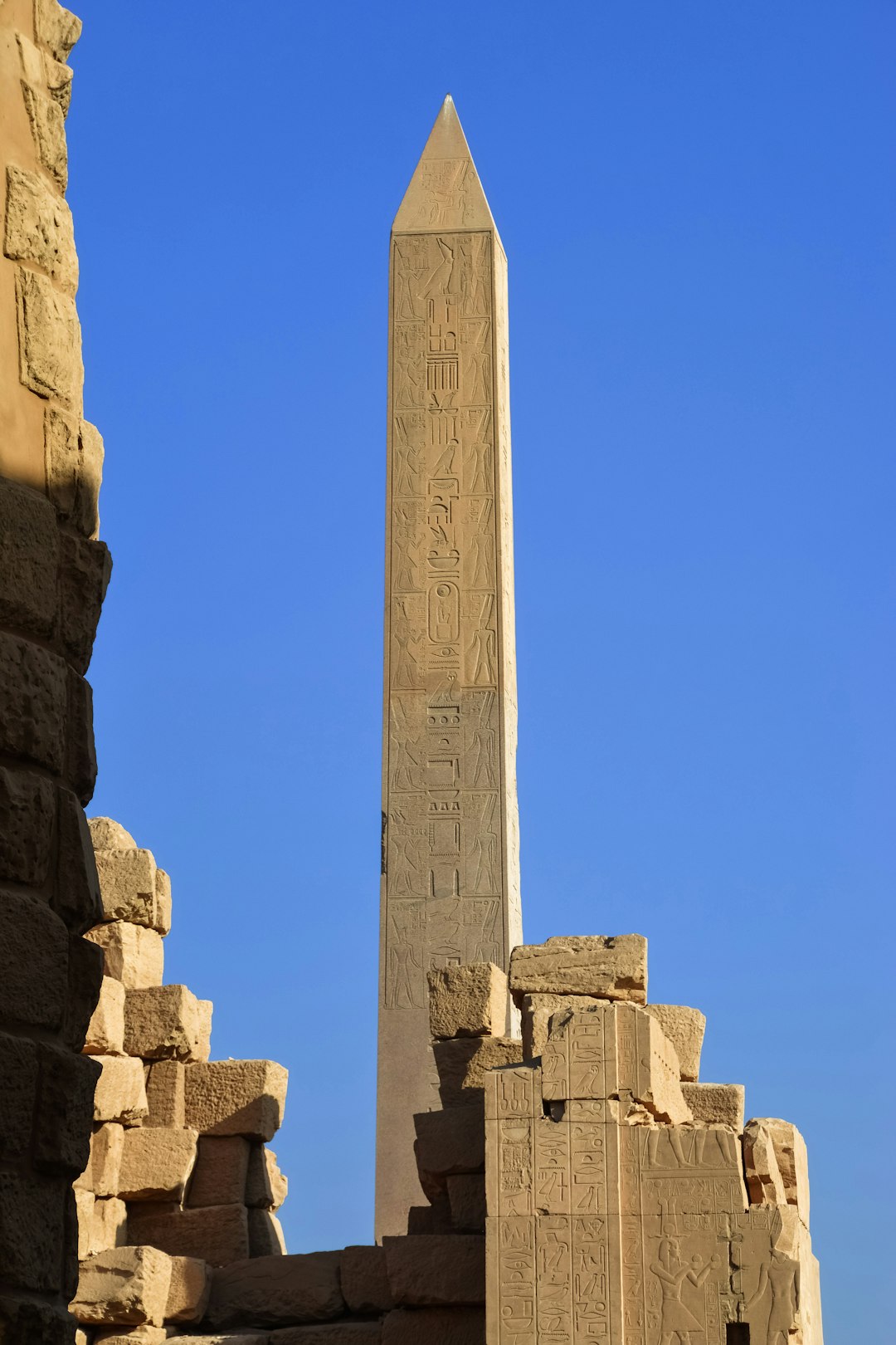 gray concrete cross on brown rock formation under blue sky during daytime