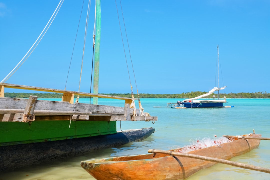 white sail boat on sea shore during daytime