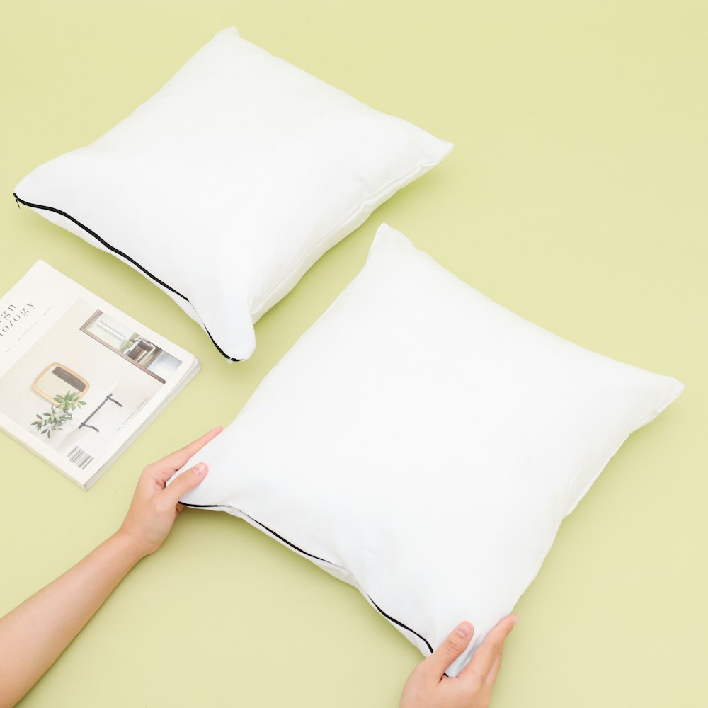 person holding white throw pillow