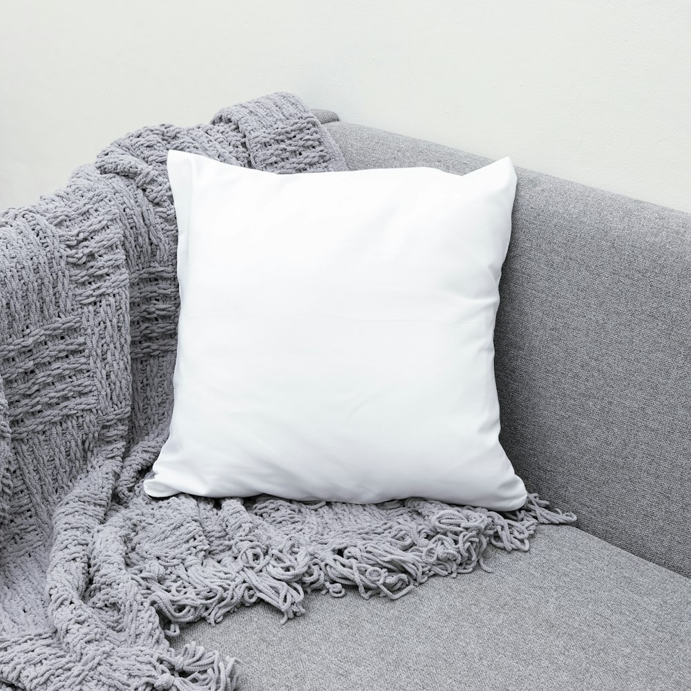 灰色のソファに白い枕を投げる