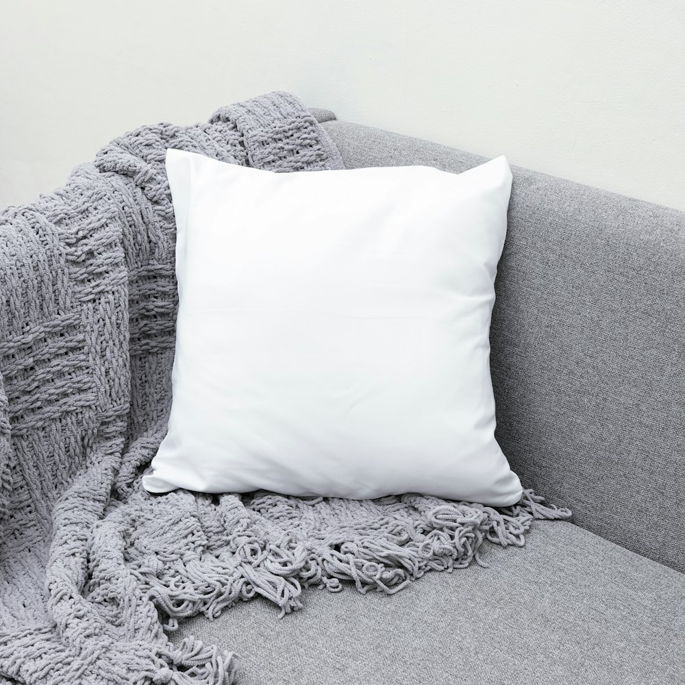 coussin blanc sur canapé gris