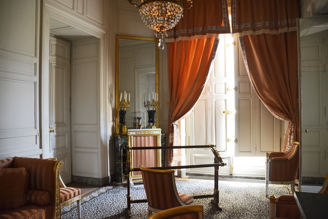 brown wooden armchair near brown window curtain