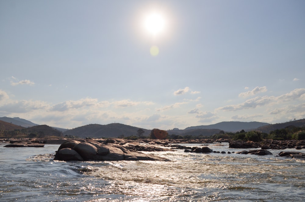 brown rock formation on body of water during daytime