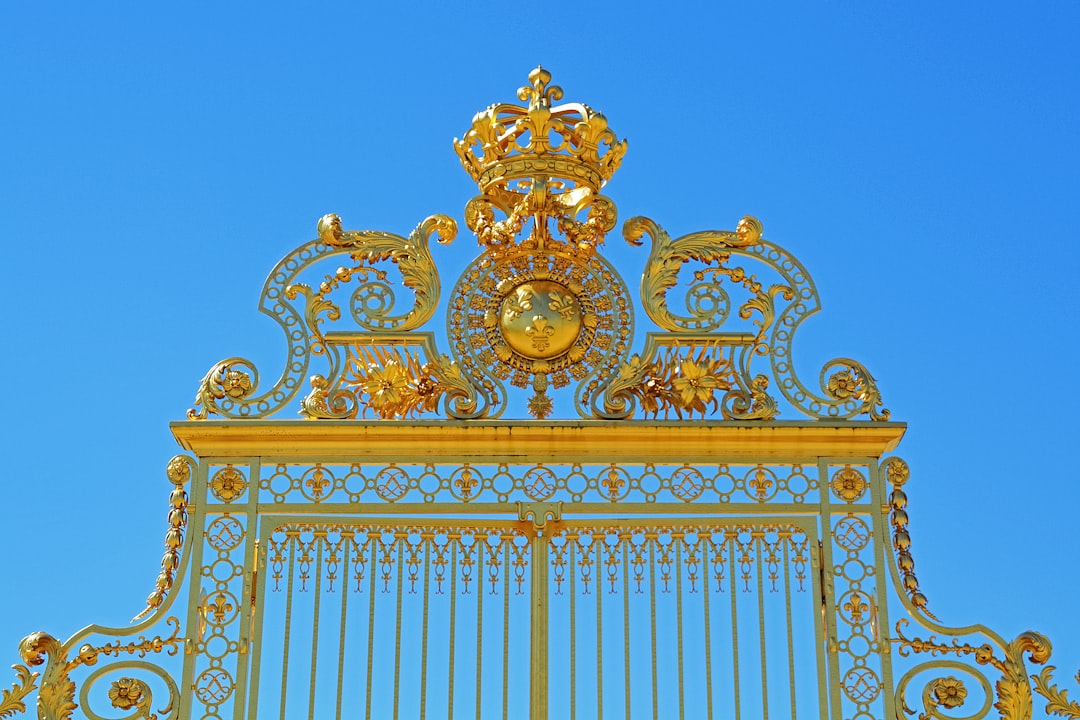 gold floral arch gate under blue sky during daytime