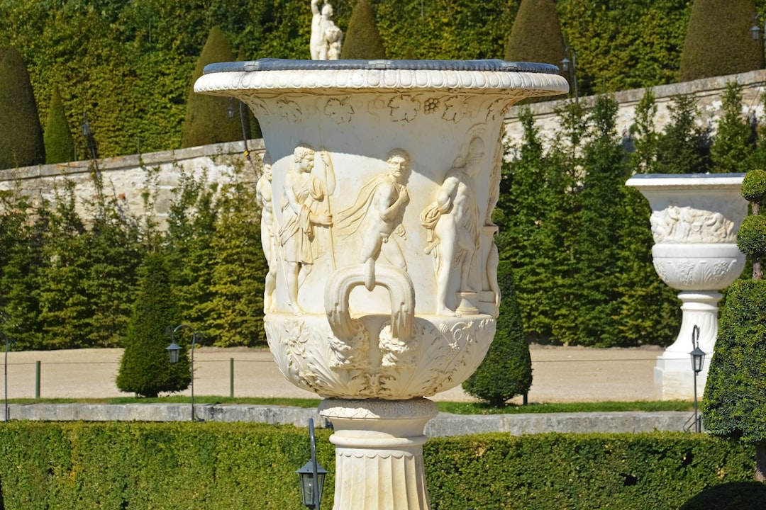 white concrete statue near green grass field during daytime