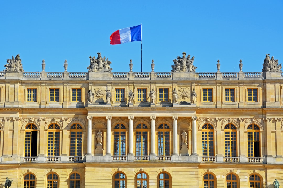 beige concrete building with flags on top during daytime