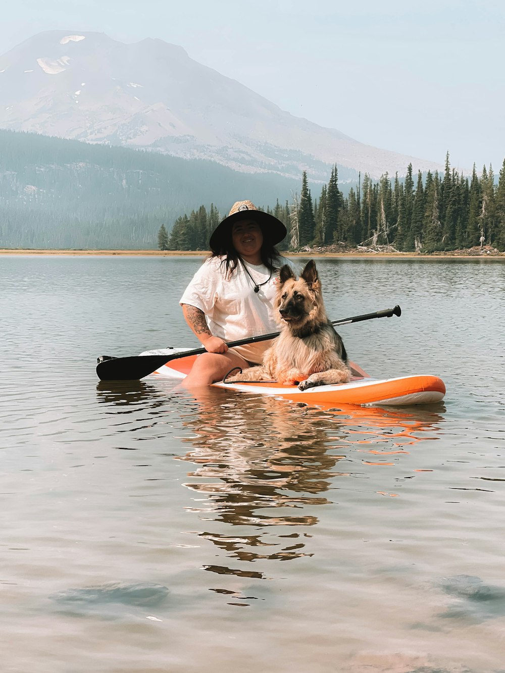 woman in white shirt riding orange kayak on lake during daytime