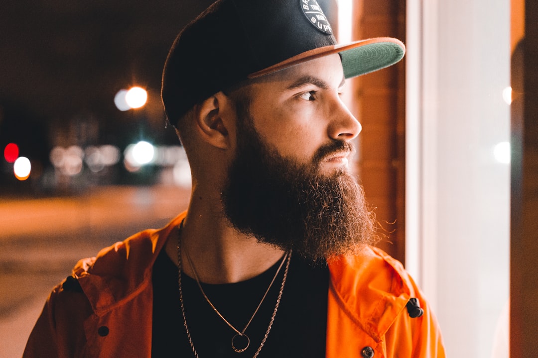 man in orange jacket wearing black cap