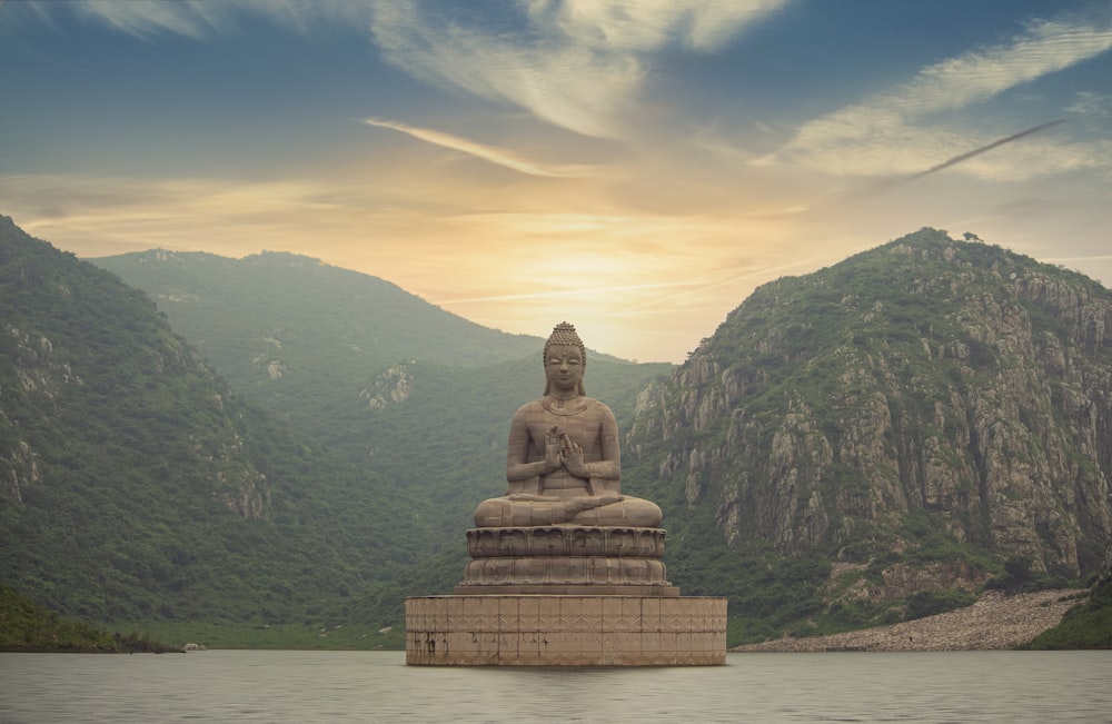 Statua di Buddha marrone vicino alla montagna verde sotto il cielo blu durante il giorno