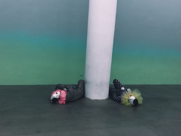 A quirky Wes Anderson-inspired scene featuring a minimalist clown and drummer duo in vintage costumes, set against a pastel-colored backdrop.