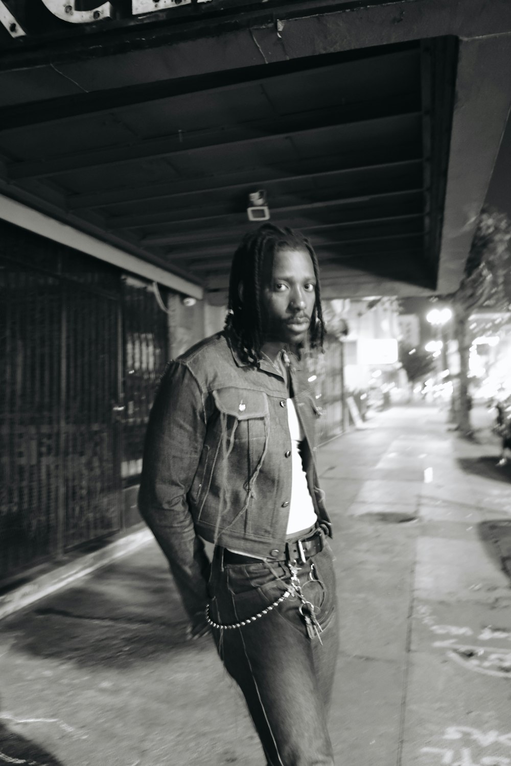 a man standing on a sidewalk in front of a building