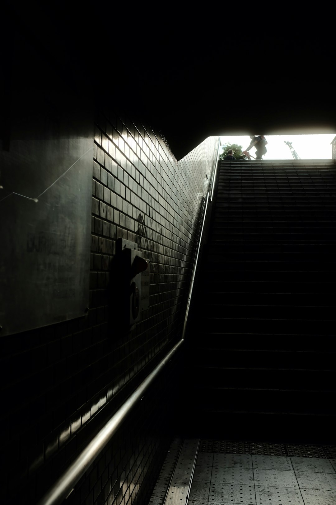 grayscale photo of person walking on stairs