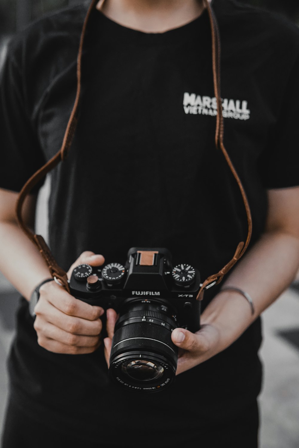 man in black t-shirt holding black nikon dslr camera