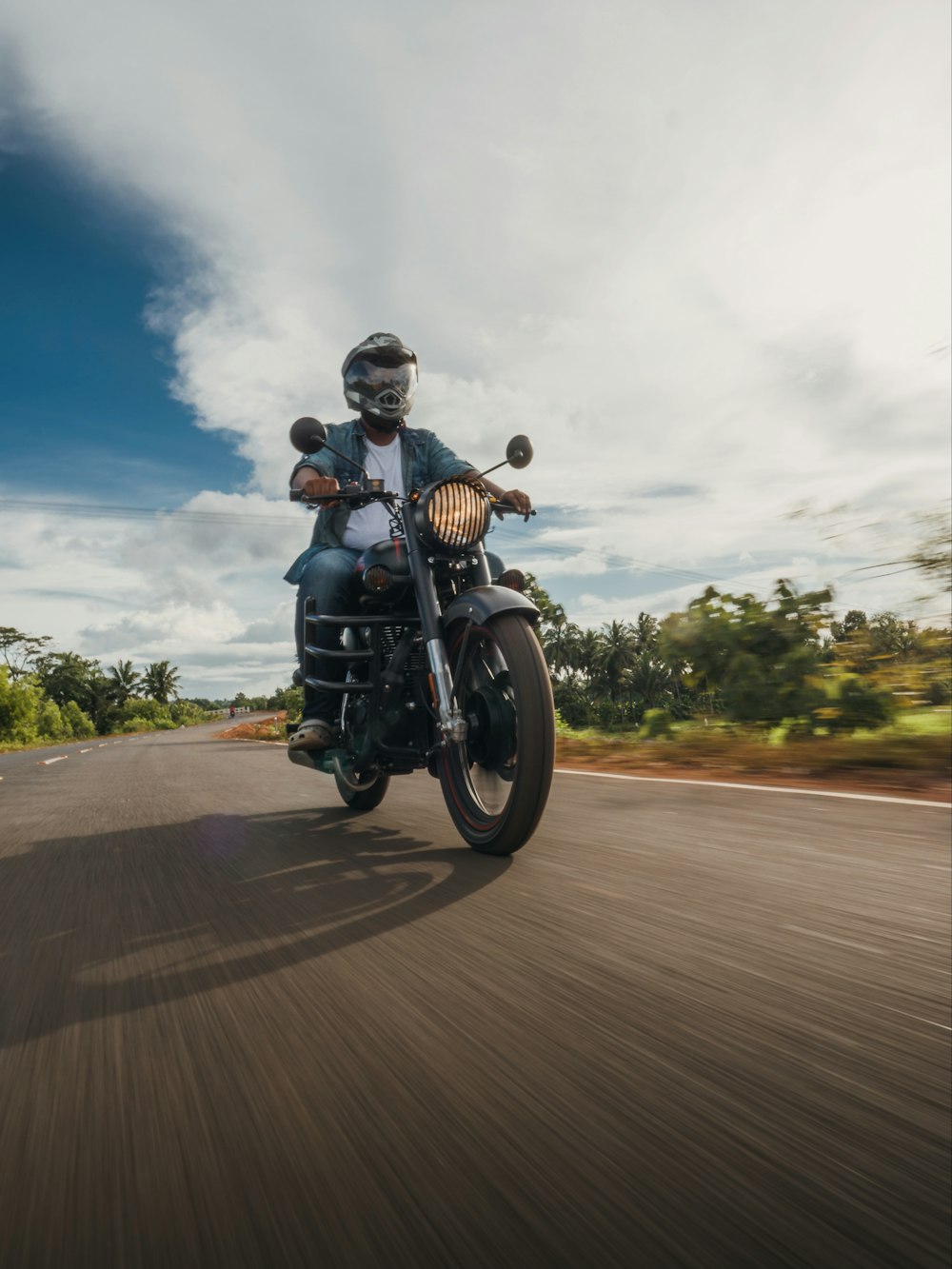 man in blue jacket riding motorcycle on road during daytime