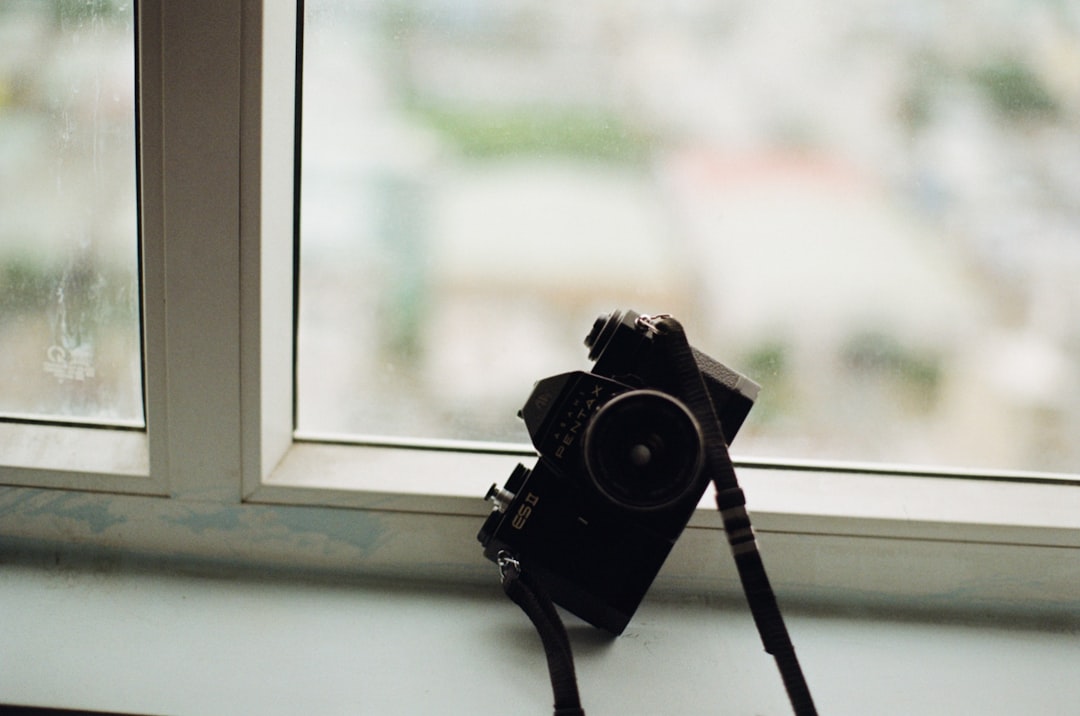 black dslr camera on white wooden window