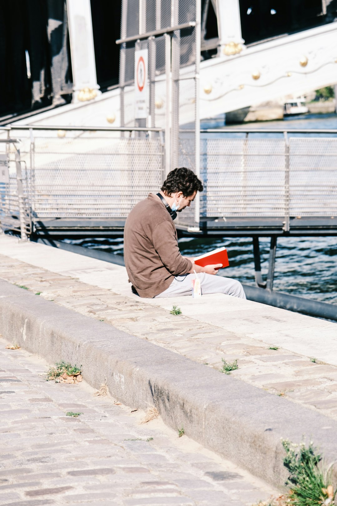 man in gray long sleeve shirt sitting on gray concrete bench during daytime