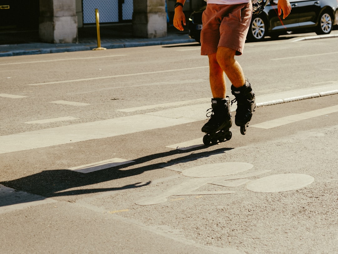 man in black leather boots and red shorts running on road during daytime