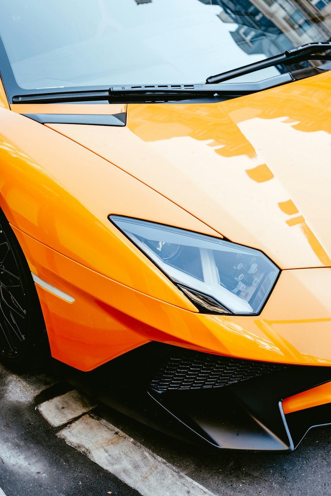 orange lamborghini aventador on gray asphalt road during daytime