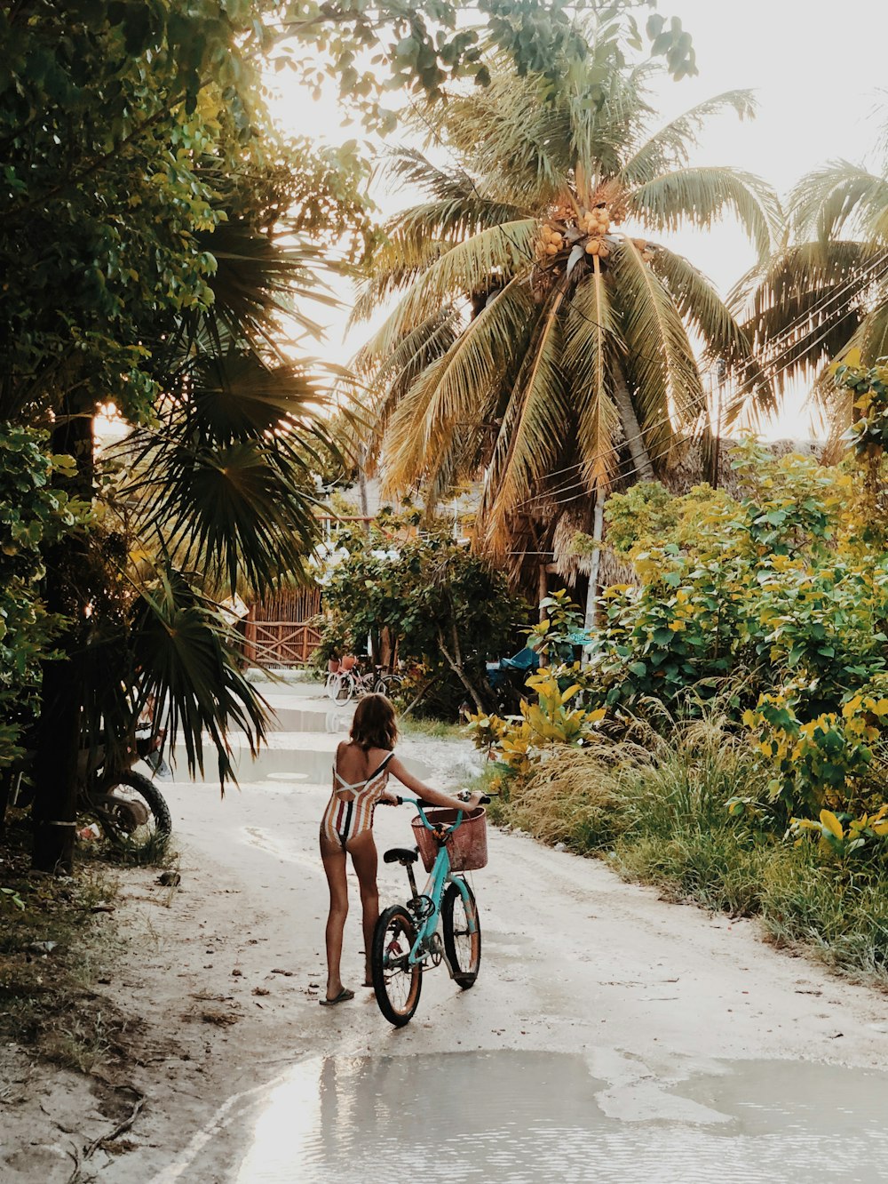 woman in pink tank top riding bicycle on road during daytime