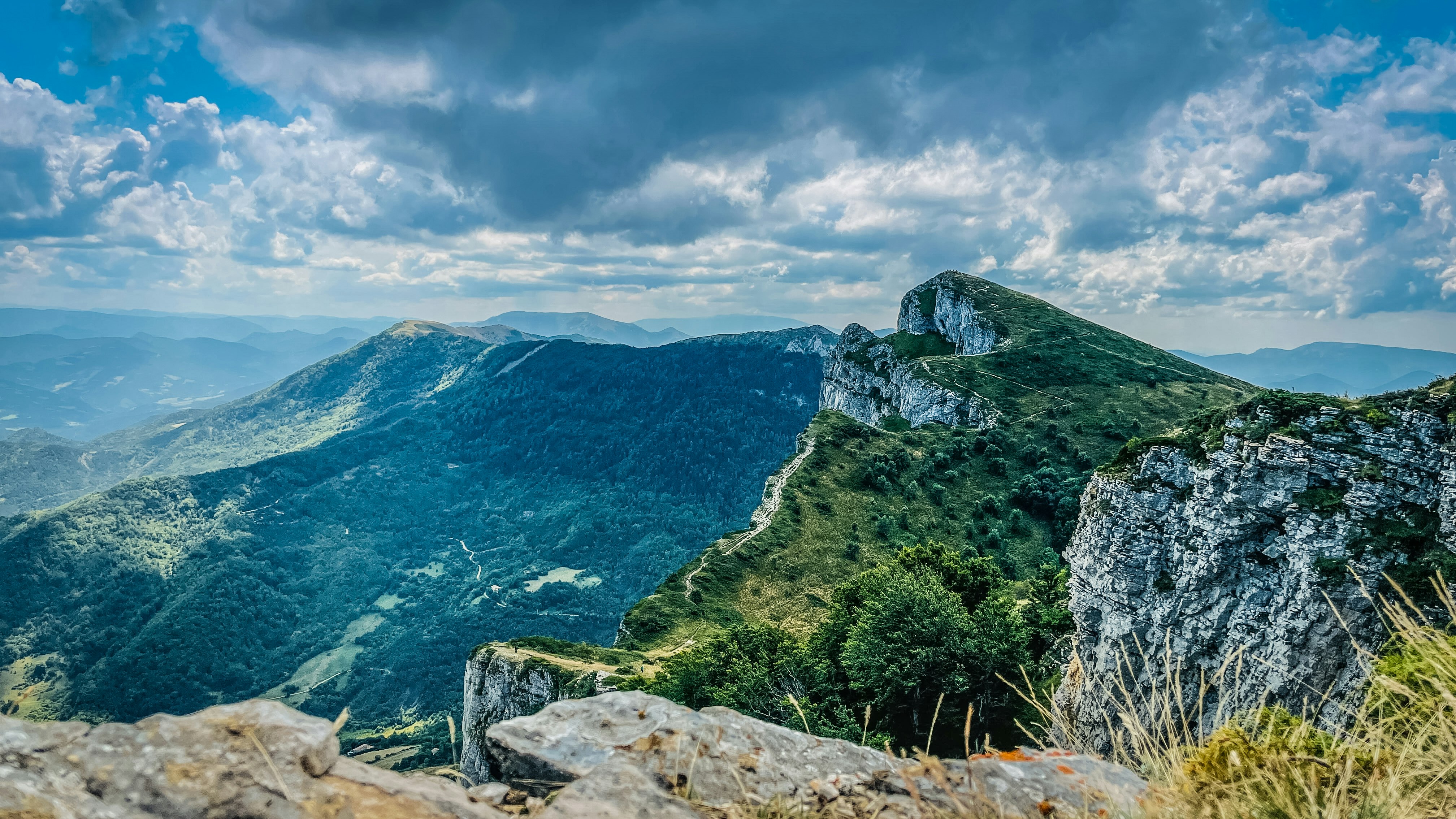 green and brown mountain beside blue sea under blue sky during daytime