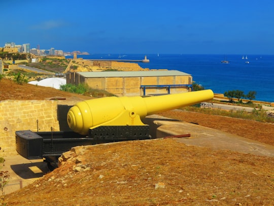 yellow metal pipe on brown sand near body of water during daytime in Fort Rinella Malta