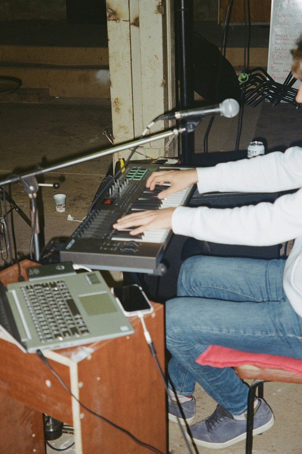 person in white and black long sleeve shirt and blue denim jeans sitting on chair