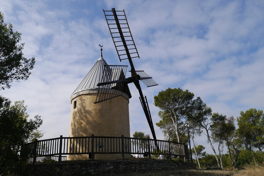 Mulino a vento marrone sotto il cielo blu durante il giorno