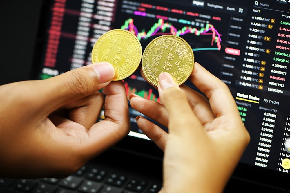 person holding gold round coin