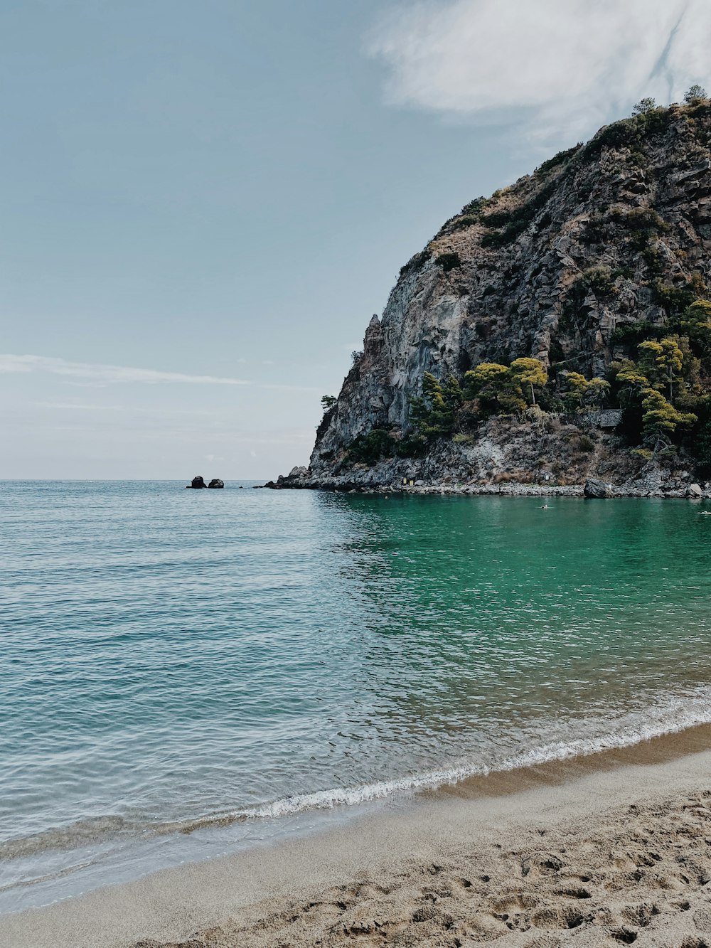 Persona con camisa negra de pie en la orilla del mar durante el día
