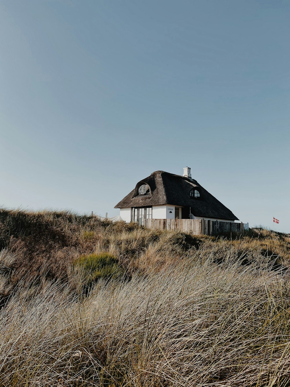 white and black house on green grass field under blue sky during daytime