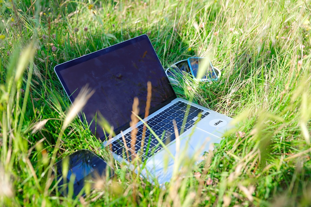 black and silver laptop computer on green grass