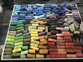 Soft pastel art prints arranged neatly on a wooden table